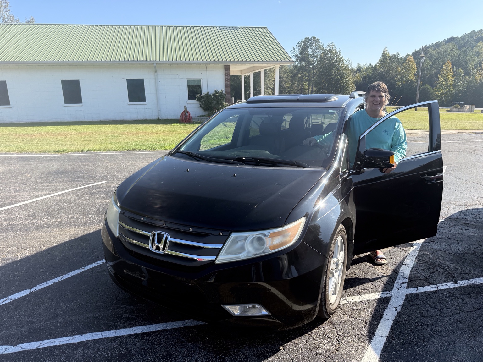Billy beside the black Honda Odyssey at the Bryan Clay House